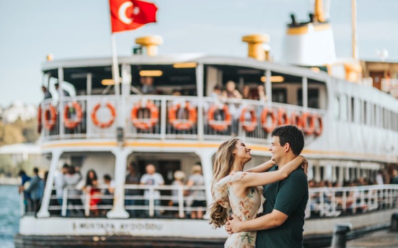 man and woman standing and hugging while facing each other near cruise ship